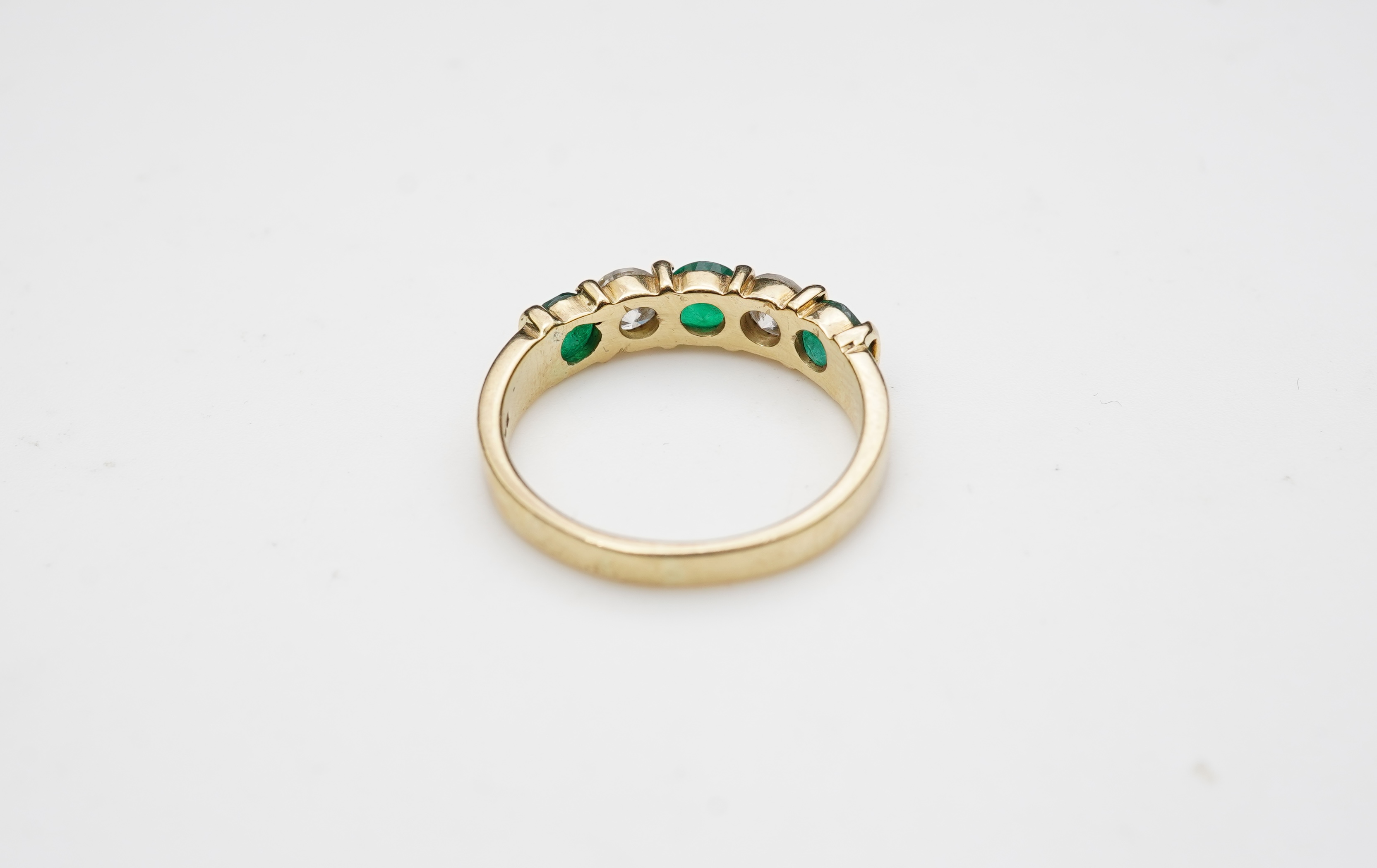 An emerald and diamond five-stone ring